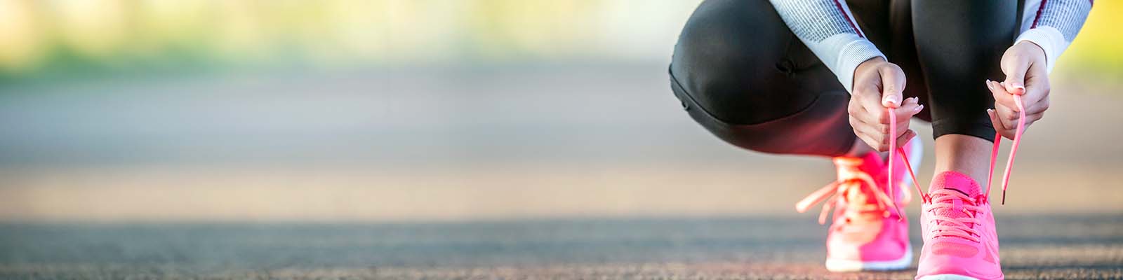 Woman runner tying shoelaces before going jogging